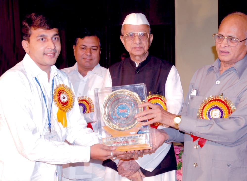 Manish Dhalawat receiving the Rashtriya Udyog Ratna Award trophy on stage